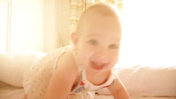 Menina feliz aprendendo a rastejar na cama — Vídeo de Stock