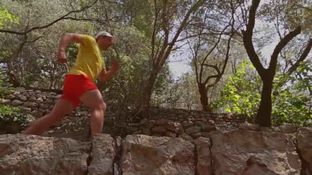 Fotografía en cámara lenta de un atleta corriendo por el paisaje mediterráneo — Vídeos de Stock