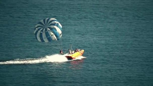Budva, Montenegro - juli 26, 2018. Parasailen parachute en speedboot op zee — Stockvideo