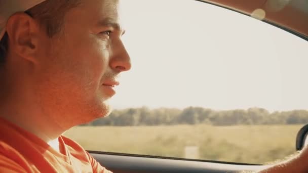 Впевнений чоловік водить машину в сонячний літній день, крупним планом — стокове відео