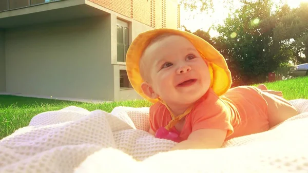 Sladké dítě na ručník na trávě — Stock fotografie