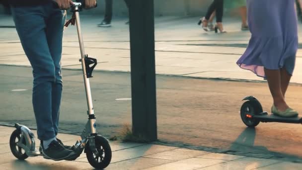 Ismeretlen emberek lovagolni egy elektromos robogó és egy hagyományos robogó — Stock videók