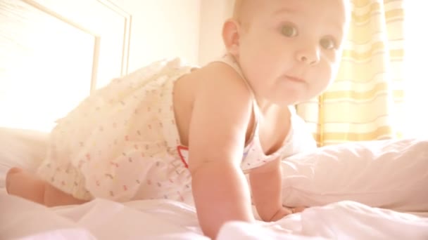 Niña en la cama en el dormitorio soleado — Vídeos de Stock