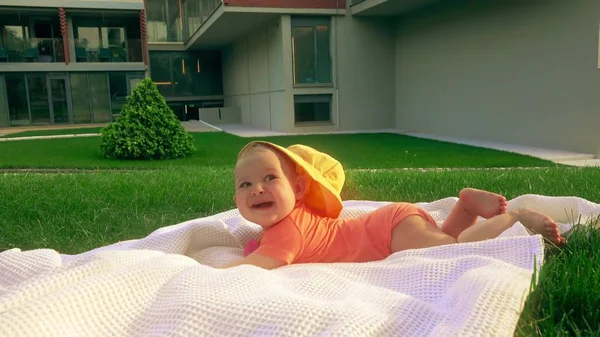 Bébé fille souriante essayant de ramper sur l'herbe — Photo
