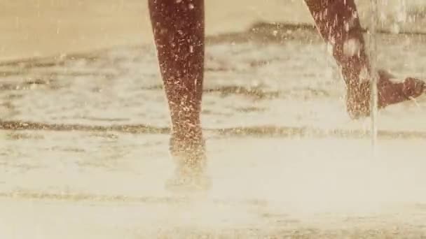 Медленный кадр босоногого человека в фонтане в жаркий летний день — стоковое видео
