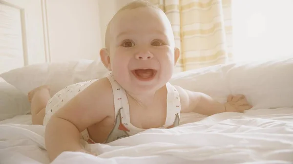 Bébé souriant essaie de ramper dans la chambre ensoleillée — Photo