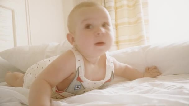 Usmívající se dítě snaží plazit a prosluněná ložnice — Stock video