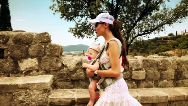 Maman et son enfant voyageant avec le sac à dos de porte-bébé en vacances — Video