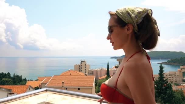 Belle femme debout sur la terrasse avec vue sur la mer un jour d'été — Video