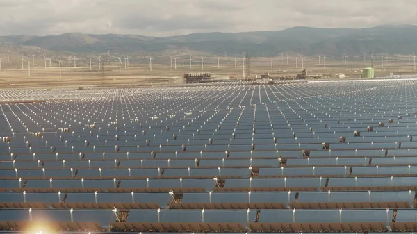 Luftaufnahme von Solarkraftwerken und weit entfernten Windkraftanlagen in niedriger Höhe — Stockfoto