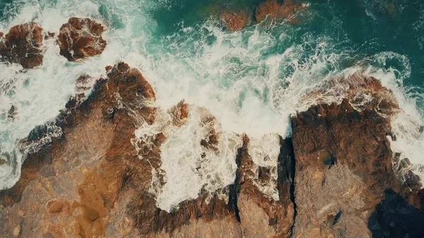 Vista aérea de arriba hacia abajo del mar espumoso surf sobre rocas — Foto de Stock