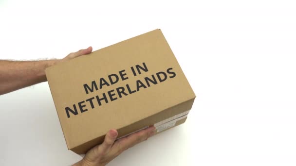 Man holding carton with MADE IN NETHERLANDS caption — Stock Video