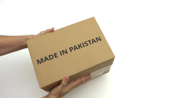 Hands hold carton with MADE IN PAKISTAN text — Stock Video