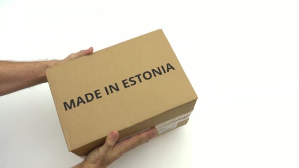 O homem entrega a caixa com texto MADE IN ESTONIA nela — Vídeo de Stock