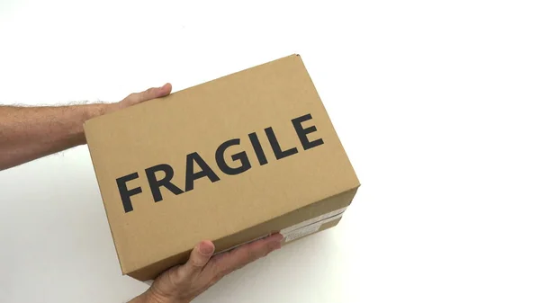 Человек держит коробку с текстом FRAGILE — стоковое фото