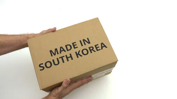 Man holds carton with MADE IN SOUTH KOREA text — Stock Photo, Image