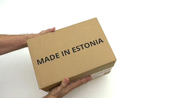 O homem entrega a caixa com texto MADE IN ESTONIA nela — Fotografia de Stock