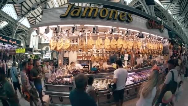 Valencia, Španělsko - 22 září 2018. Rybí oko objektivu pohled jamon masných specialit stánek v Mercado Central nebo centrální trh — Stock video