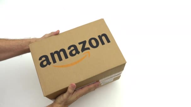 Logotipo AMAZON en la caja de cartón en las manos. Clip editorial — Vídeos de Stock