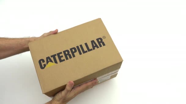 Händer som håller låda med Caterpillar-logotyp. Redaktionella klipp — Stockvideo
