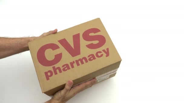 Man met karton met Cvs apotheek logo. Redactionele clip — Stockvideo