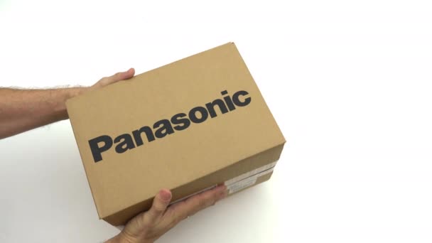Adam kutu Panasonic logosu ile tutar. Editoryal klip — Stok video