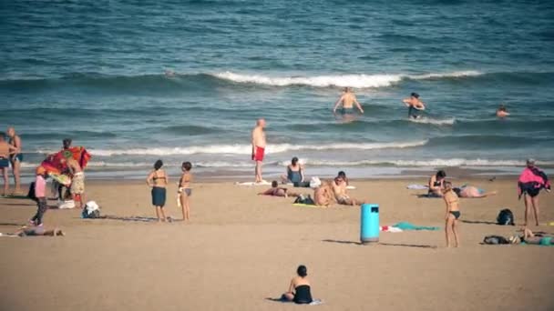 VALENCIA, ESPANHA - 22 de setembro de 2018. Pessoas nadando e tomando sol na praia da cidade arenosa — Vídeo de Stock