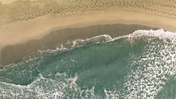 Vista aérea de arriba hacia abajo del mar surf en la playa de arena con muchas huellas — Vídeos de Stock