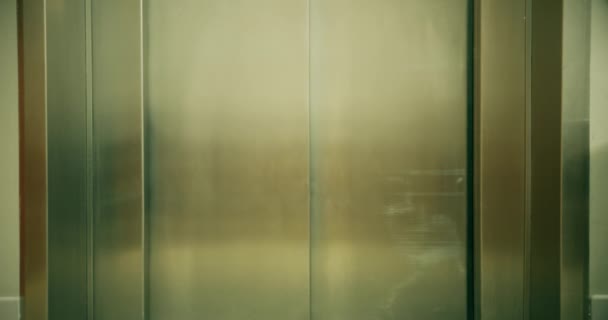 Человек с чемоданом выходит из лифта отеля — стоковое видео