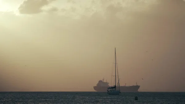 Segelboote gegen Frachtschiff auf hoher See — Stockfoto