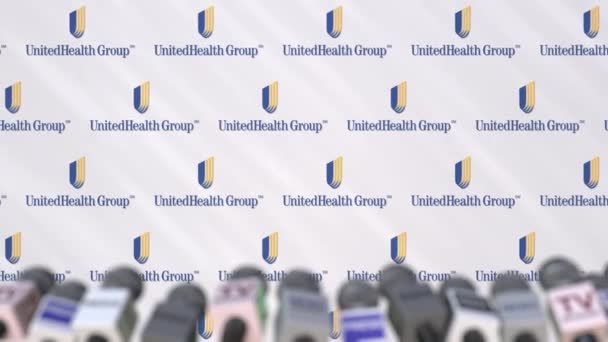 Konferensi pers UNITEDHEALTH GROUP, dinding pers dengan logo dan mikrofon, animasi editorial konseptual — Stok Video