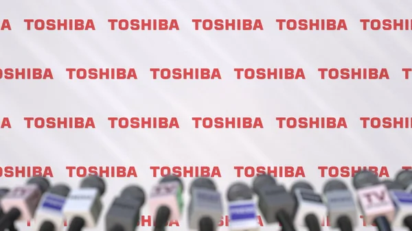 Mediehändelse av Toshiba, tryck på väggen med logotyp och mikrofoner, redaktionella 3d-rendering — Stockfoto