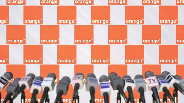 オレンジのロゴとマイク、編集 3 d レンダリング プレス壁のメディア イベント — ストック写真