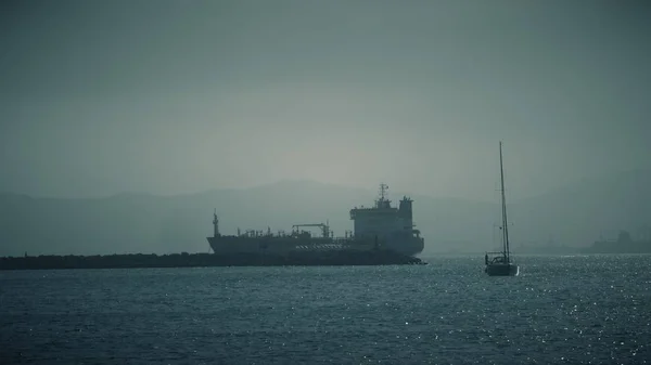 Unbekanntes Segelboot und Frachtschiff auf See bei Gibraltar — Stockfoto