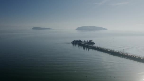 桟橋と遠くの島にドッキングされたモーター ボートの空撮 — ストック動画
