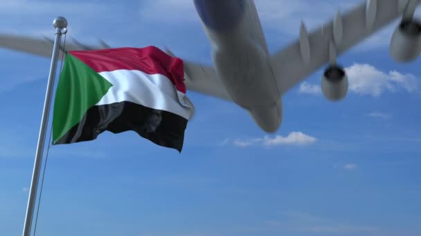 Avión comercial aterrizando detrás ondeando bandera sudanesa. Viaje a Sudán animación conceptual — Vídeos de Stock