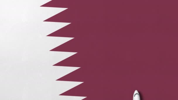 Top-down mening van het vliegtuig op de vlag van Qatar. Toerisme gerelateerde conceptuele 3d animatie — Stockvideo