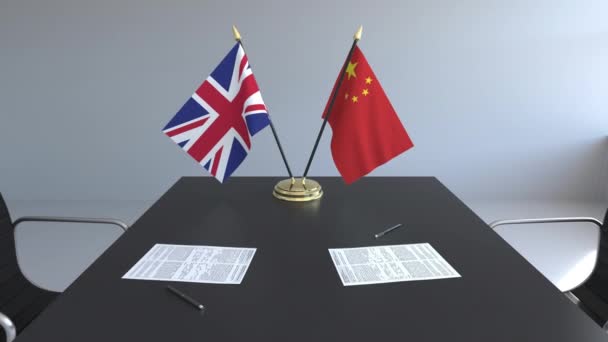 Flaggen von Großbritannien und China und Papiere auf dem Tisch. Verhandlungen und die Unterzeichnung eines internationalen Abkommens. konzeptionelle 3D-Animation — Stockvideo