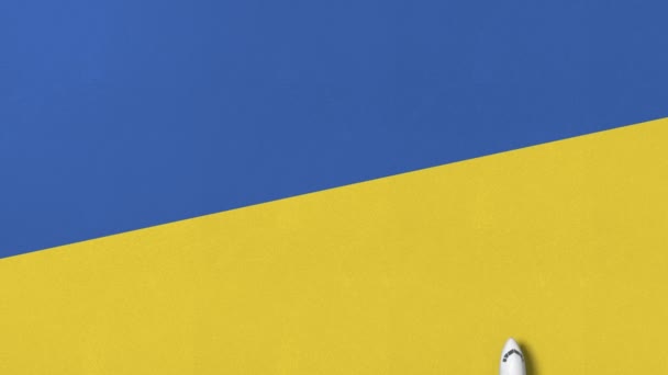 Сверху вниз вид самолета на флаг Украины. Концептуальная 3D анимация — стоковое видео