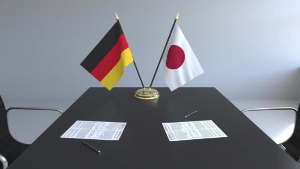 Flaggen von Deutschland und Japan und Papiere auf dem Tisch. Verhandlungen und die Unterzeichnung eines internationalen Abkommens. konzeptionelle 3D-Animation — Stockvideo