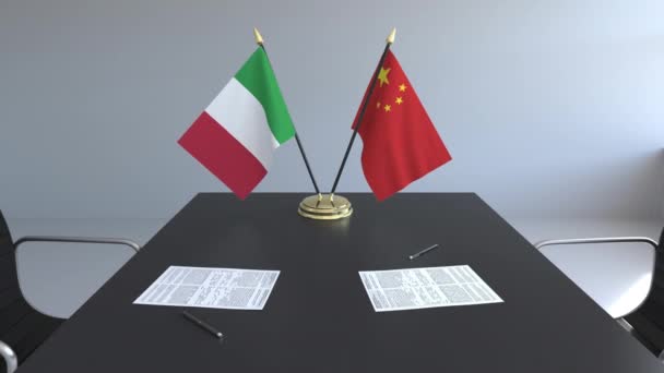 Флаги Италии и Китая и бумаги на столе. Переговоры и подписание международного соглашения. Концептуальная 3D анимация — стоковое видео