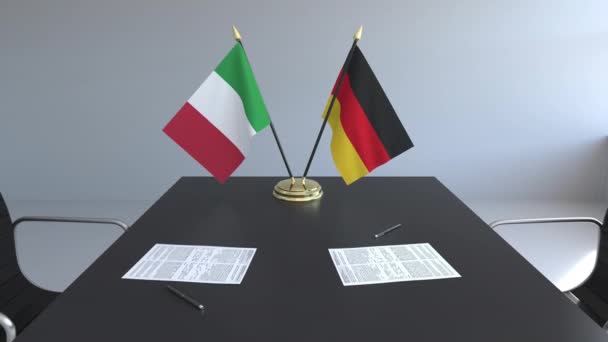 Флаги Италии и Германии и бумаги на столе. Переговоры и подписание международного соглашения. Концептуальная 3D анимация — стоковое видео