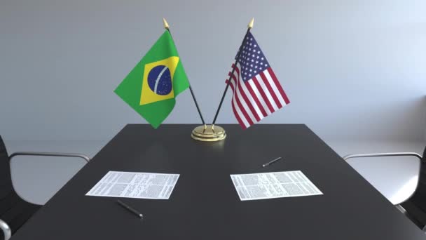 Banderas de Brasil y Estados Unidos y documentos sobre la mesa. Negociaciones y firma de un acuerdo internacional. Animación 3D conceptual — Vídeo de stock