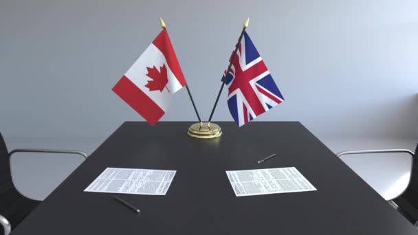 Banderas de Canadá y Gran Bretaña y papeles sobre la mesa. Negociaciones y firma de un acuerdo internacional. Animación 3D conceptual — Vídeos de Stock