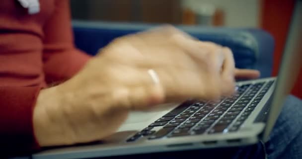 El hombre con ropa casual trabaja en su computadora portátil, primer plano del teclado — Vídeo de stock