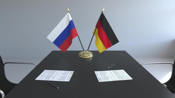 Flaggen Russlands und Deutschlands und Papiere auf dem Tisch. Verhandlungen und die Unterzeichnung eines internationalen Abkommens. konzeptionelle 3D-Animation — Stockvideo