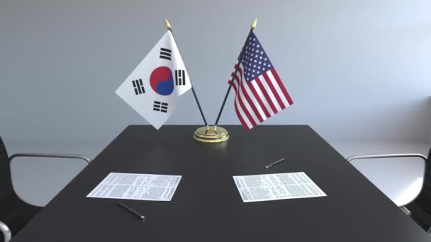 Banderas de Corea del Sur y Estados Unidos y documentos sobre la mesa. Negociaciones y firma de un acuerdo internacional. Animación 3D conceptual — Vídeos de Stock