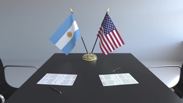 Banderas de Argentina y Estados Unidos y documentos sobre la mesa. Negociaciones y firma de un acuerdo internacional. Animación 3D conceptual — Vídeo de stock