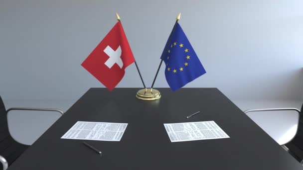 Flaggen der Schweiz und der Europäischen Union und Papiere auf dem Tisch. Verhandlungen und die Unterzeichnung eines internationalen Abkommens. konzeptionelle 3D-Animation — Stockvideo