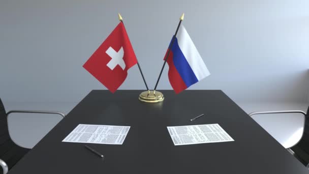 Banderas de Suiza y Rusia y papeles sobre la mesa. Negociaciones y firma de un acuerdo internacional. Animación 3D conceptual — Vídeos de Stock